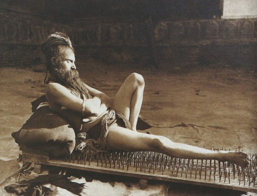 Indian fakir mystic lying on bed of nails