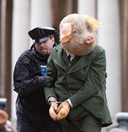 One of the three big pigs in handcuffs.