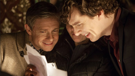 Martin Freeman as John Watson and Benedict Cumberbatch as Sherlock Holmes smile over the script